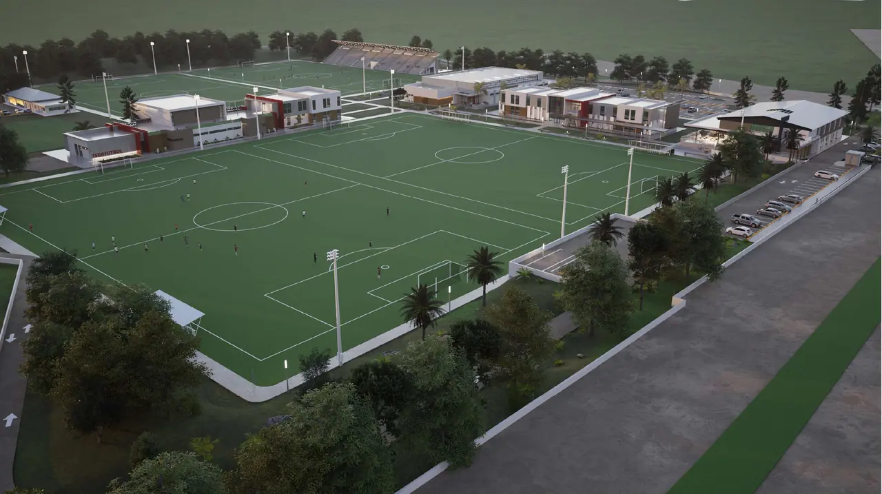 Render aéreo del complejo al atardecer, con los campos de fútbol, las edificaciones y los estacionamientos